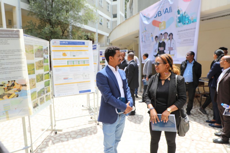 Dr Bitew Kassaw and Dr Adey Nigatu stand together in front of posters on display boards from the Ethiopia team